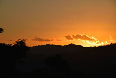 Scenic view of silhouette trees against orange sky