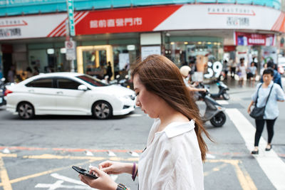 Midsection of woman standing on street in city