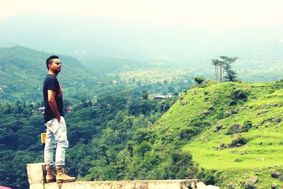 Full length of man standing on mountain against clear sky