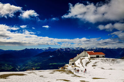 Buildings on mountain against cloudy sky