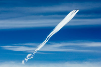 Low angle view of vapor trail against blue sky