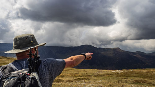 Man riding motorcycle on mountain against sky