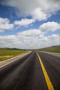 Empty road against cloudy sky