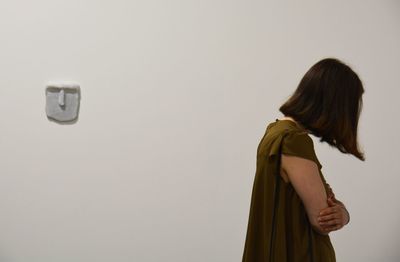Rear view of woman standing against white background