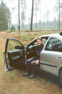 Man driving car in forest