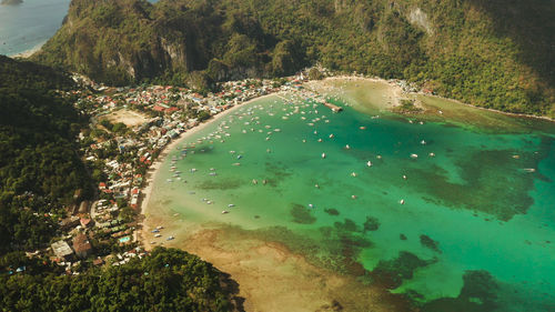 Town el nido on the coast with bay and lot tourist boats. seascape with blue bay and boats 