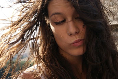 Close-up of young woman tousled hair making face