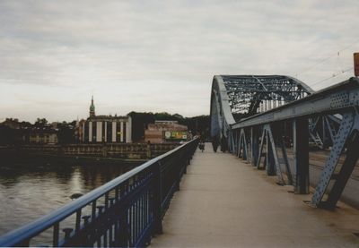 Footbridge over river with buildings in background