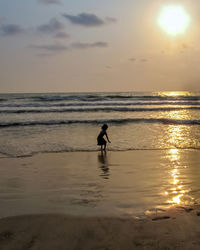 Silhouette man on beach against sky during sunset