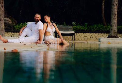 Young couple sitting in swimming pool