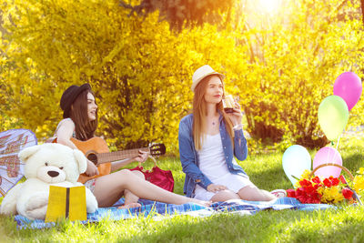 Young women sitting on grass and plants