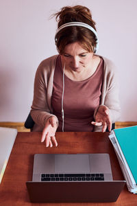 Woman using phone while sitting on table