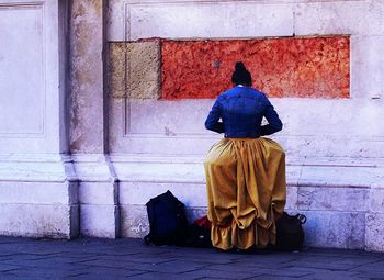 Rear view of women sitting against door