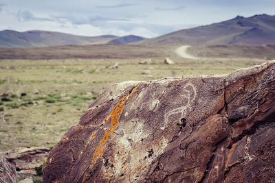 Beige backpack, bottle of water and straw hat on on top of the mountain. active travel concept.