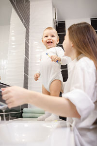 Side view of mother and son at bathroom