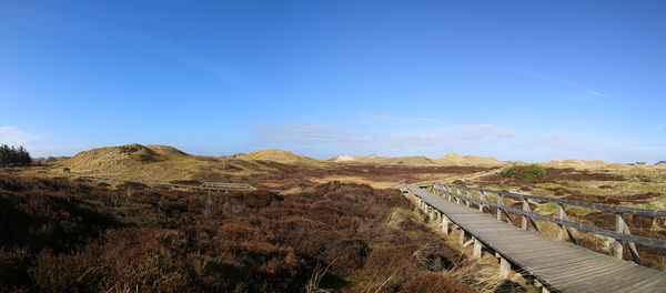 Panoramic view of landscape against blue sky