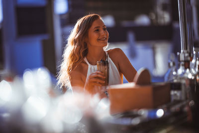 Young woman having drink at sidewalk cafe