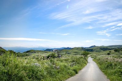 Empty road along landscape against sky