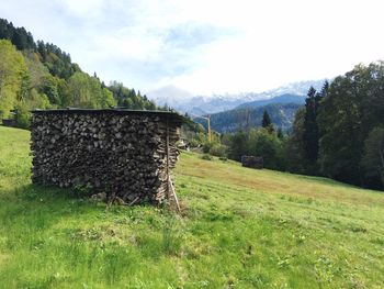 Built structure on grassy field against mountain range