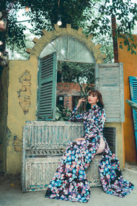 Young woman sitting on bench in city