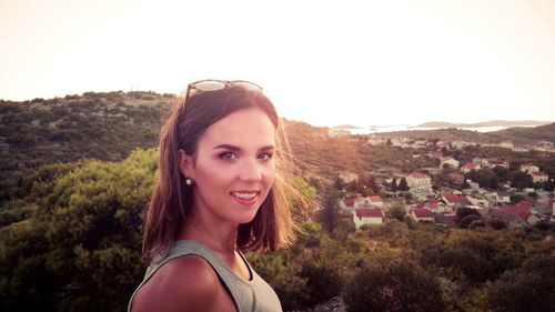 Portrait of smiling young woman against sky during sunset