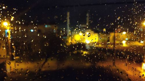 Raindrops on glass window at night