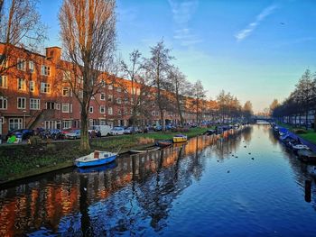 Canal amidst buildings in city against sky