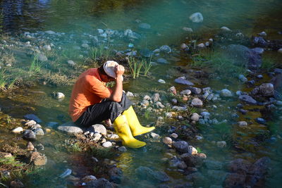 Side view of woman photographing in water