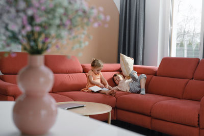 Brother and sister sitting on the sofa. siblings communicating at home, playing together. lifestyle