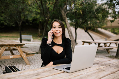 Portrait of young woman using mobile phone outdoors