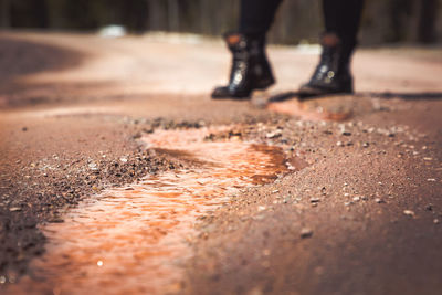 Low section of person standing on road