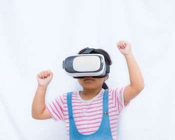 Girl wearing virtual reality simulator against white background