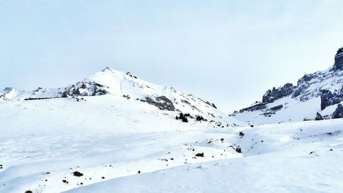 Scenic view of snow covered mountains against clear sky