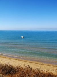 Scenic view of sea against clear blue sky