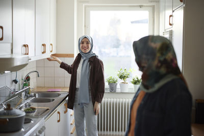 Women in headscarves cooking together for eid al-fitr at home