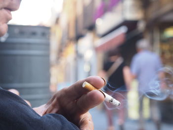 Cropped image of man hand holding cigarette