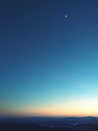 Scenic view of moon against clear blue sky at night