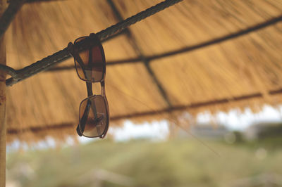 Close-up of sunglasses hanging against roof