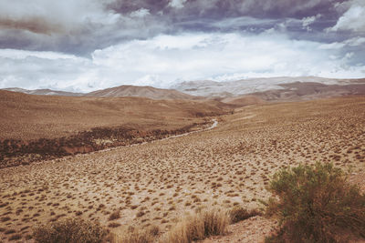 An arid and desert landscape between mountains.