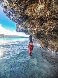 Full length of woman on rock by sea