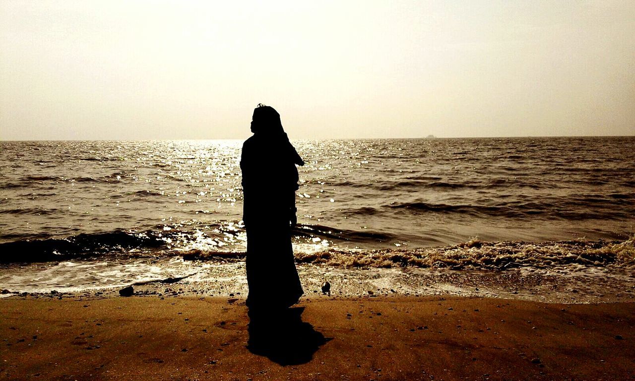 sea, horizon over water, water, clear sky, silhouette, beach, tranquil scene, tranquility, standing, shore, scenics, rear view, beauty in nature, sunset, copy space, nature, idyllic, men