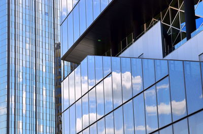 Low angle view of glass building against sky