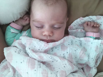 Close-up of baby sleeping in bed
