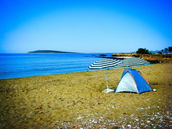 Scenic view of beach against clear blue sky