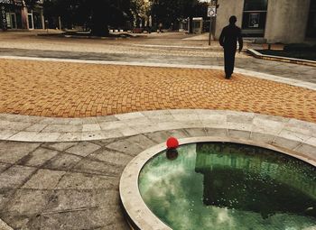 Man in swimming pool by street in city