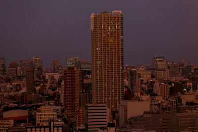 Illuminated cityscape against clear sky