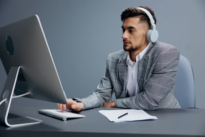 Young man using laptop at desk in office