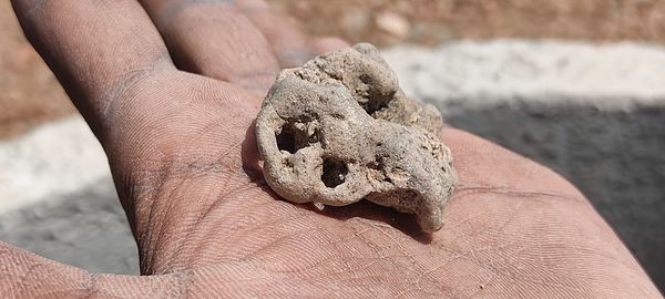 Close-up of human hand holding sand