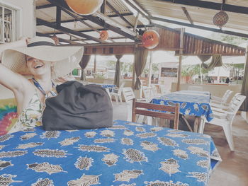 Midsection of woman with hat on table at restaurant