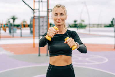 Portrait of young woman exercising in gym